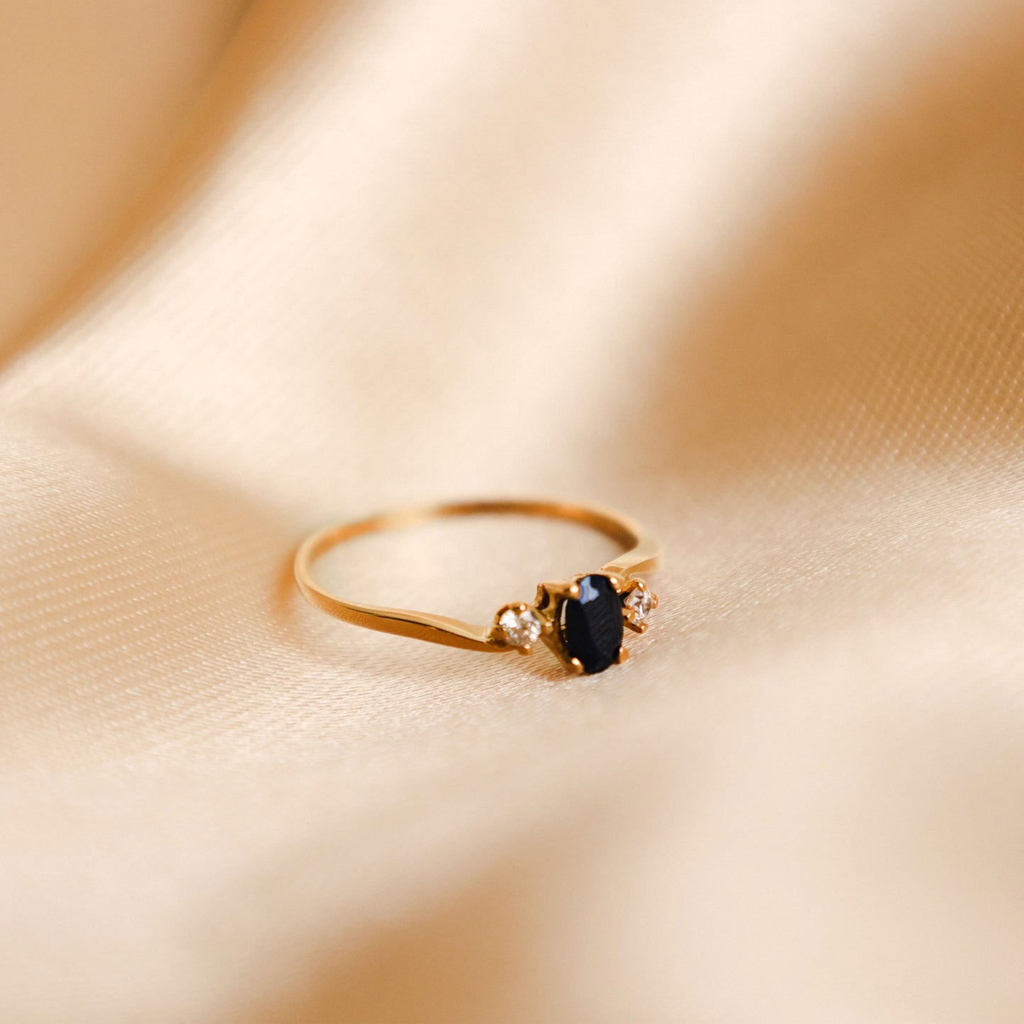 Anel delicado em Ouro de 19 quilates com design solitário moderno e elegante. Ao centro, destaca-se uma safira escura de tonalidade azul profunda - Loja do Ouro