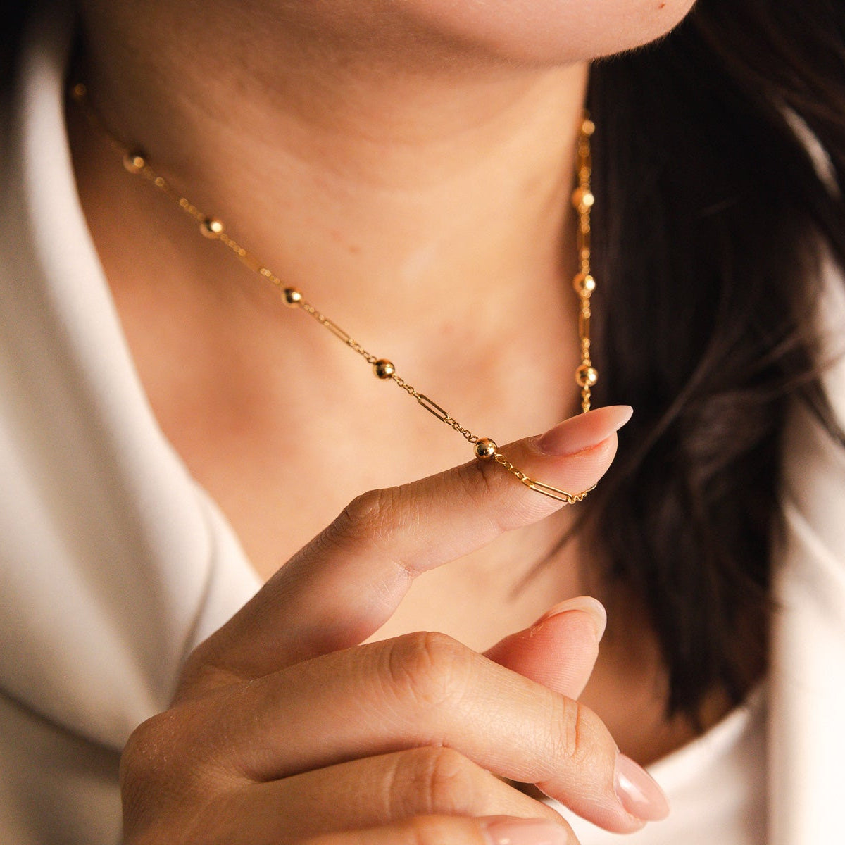 Elegante fio em Ouro de 19 quilates com design delicado e contemporâneo, composto por uma fina corrente intercalada com traves alongadas e esferas polidas - Loja do Ouro