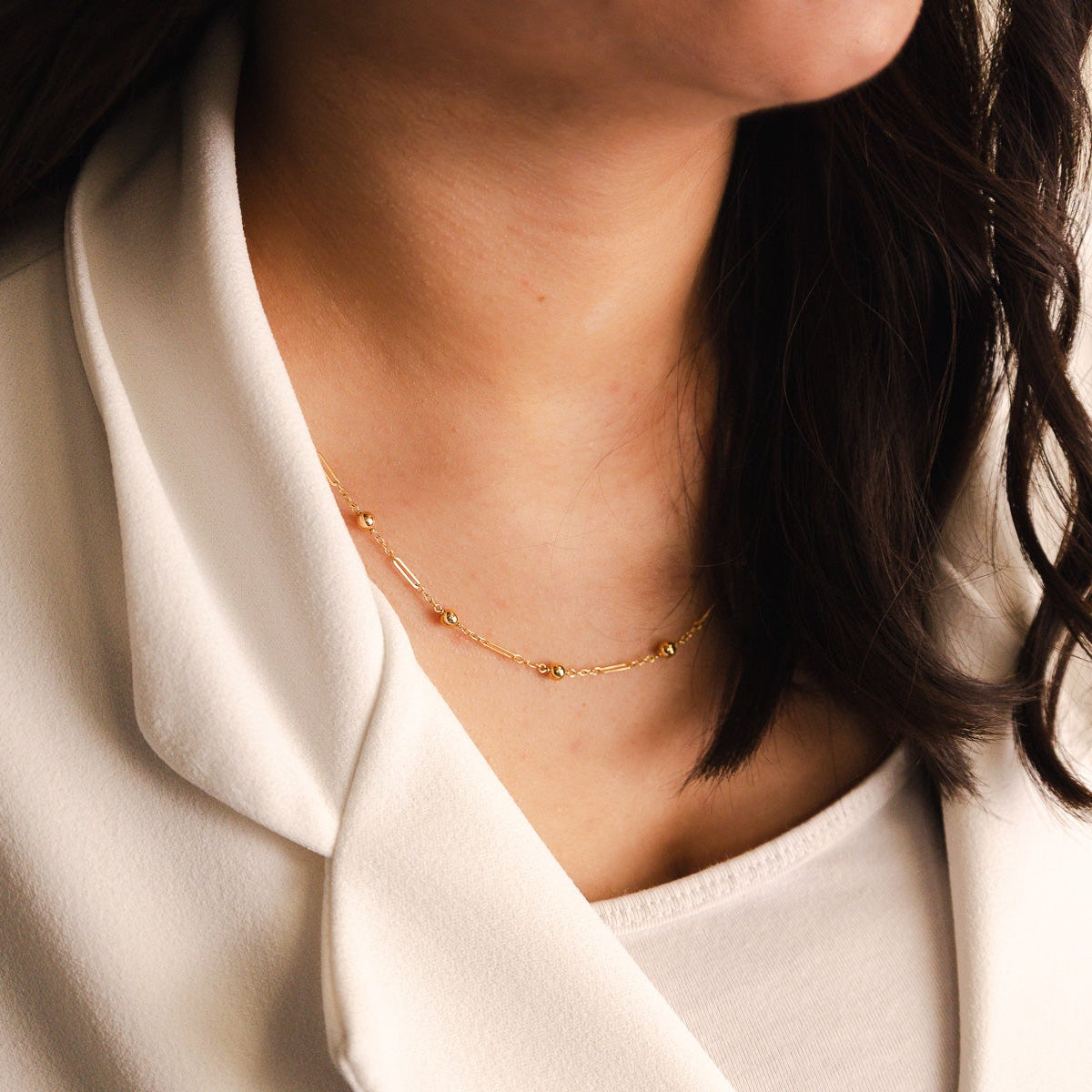 Elegante fio em Ouro de 19 quilates com design delicado e contemporâneo, composto por uma fina corrente intercalada com traves alongadas e esferas polidas - Loja do Ouro