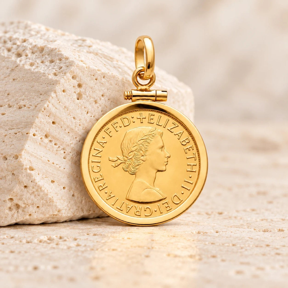 Moeda de libra da Rainha Isabel II em ouro de 22 quilates, enquadrada por aro simples em ouro de 19 quilates.
