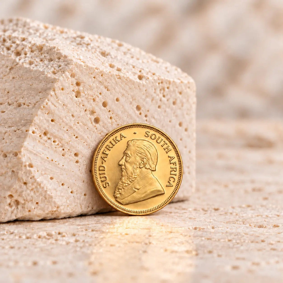 Moeda Krugerrand de 1/10 oz em ouro 916,7 milésimas, com os motivos tradicionais da série.